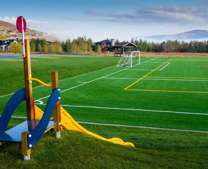 synthetic grass soccer field with a playground on the side