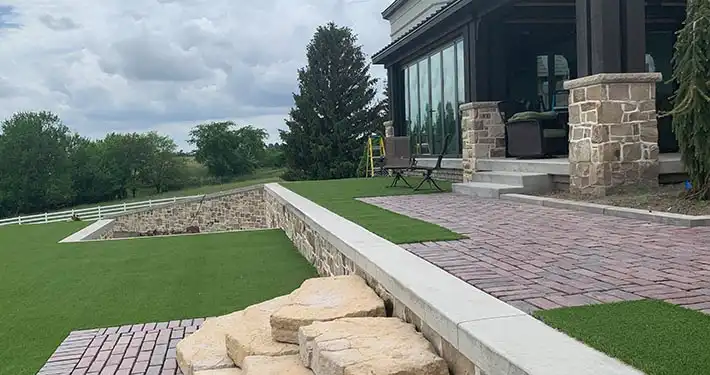 beautiful commercial building with synthetic turf and rock and brick landscaping