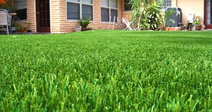 close up of artificial grass lawn in front of house