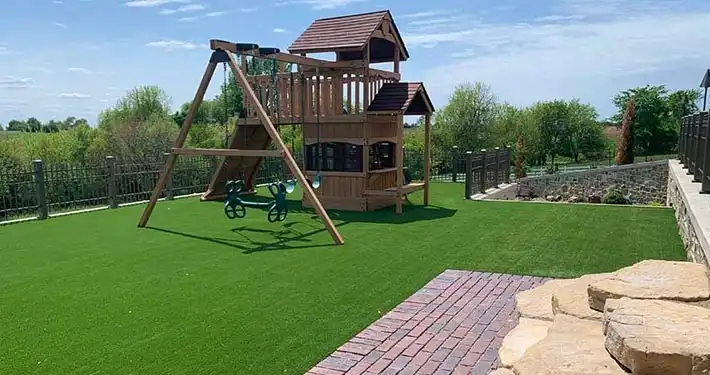 backyard wooden playground with brick and synthetic grass